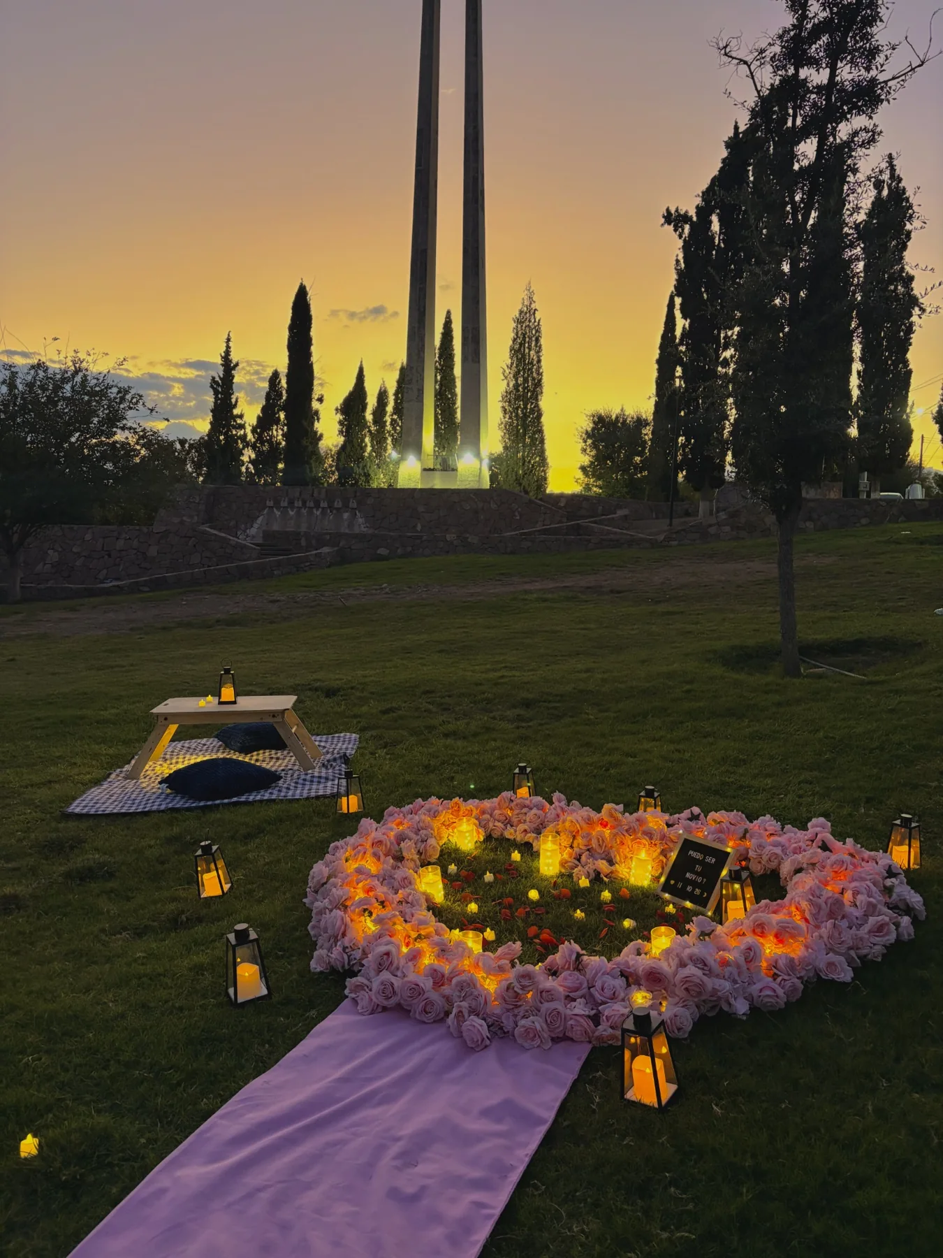 Fotografía real de Pedidas CUU: picnic romántico con pétalos y velas al atardecer
